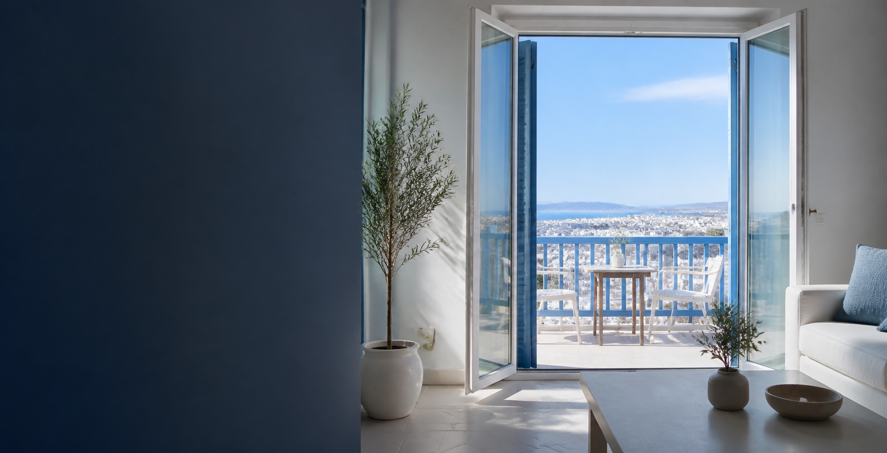 A sunlit Athens rental apartment opening onto a balcony with city views.