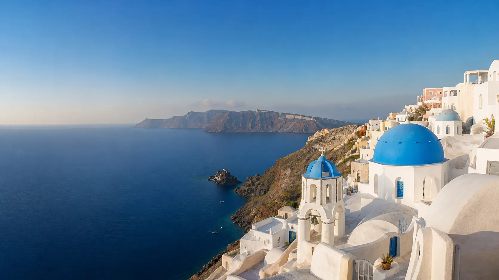 White Cycladic houses above the Aegean Sea in Santorini.
